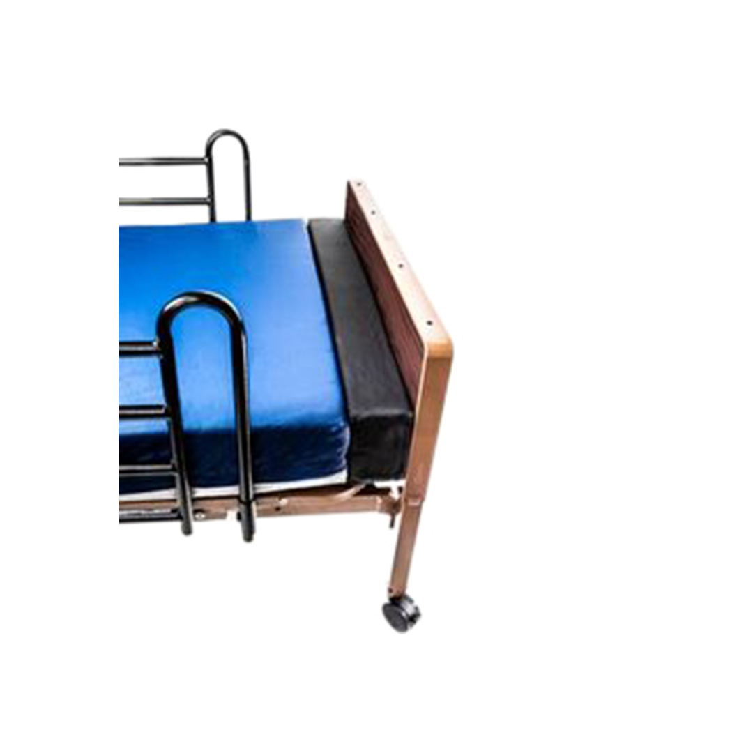 The Proactive Protekt® Mattress Extender is a 6" high foam extension for hospital beds, shown with a blue mattress, black side rail, and wooden headboard on wheels. It enhances bed safety and protection in healthcare settings.